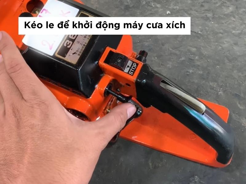 Kéo le để khởi động máy cưa xích chạy xăng