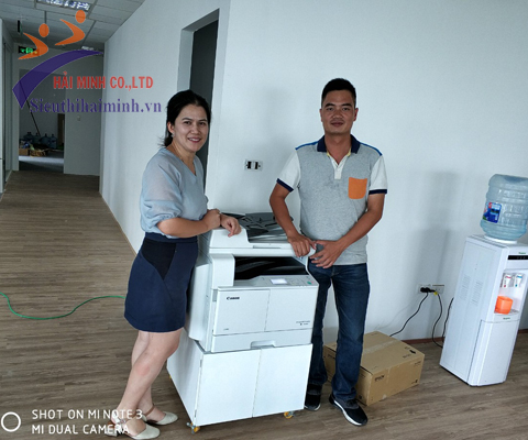 Khách hàng nhận máy photocopy từ kỹ thuật Hải Minh 